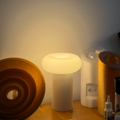 Small lamp on a surface with a textured wall in the background